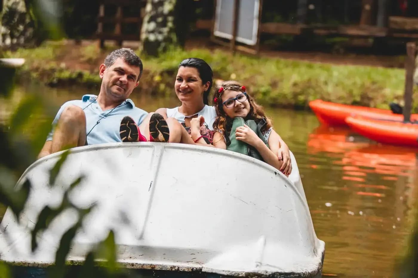 Família passeando de barco no lago do hotel fazenda